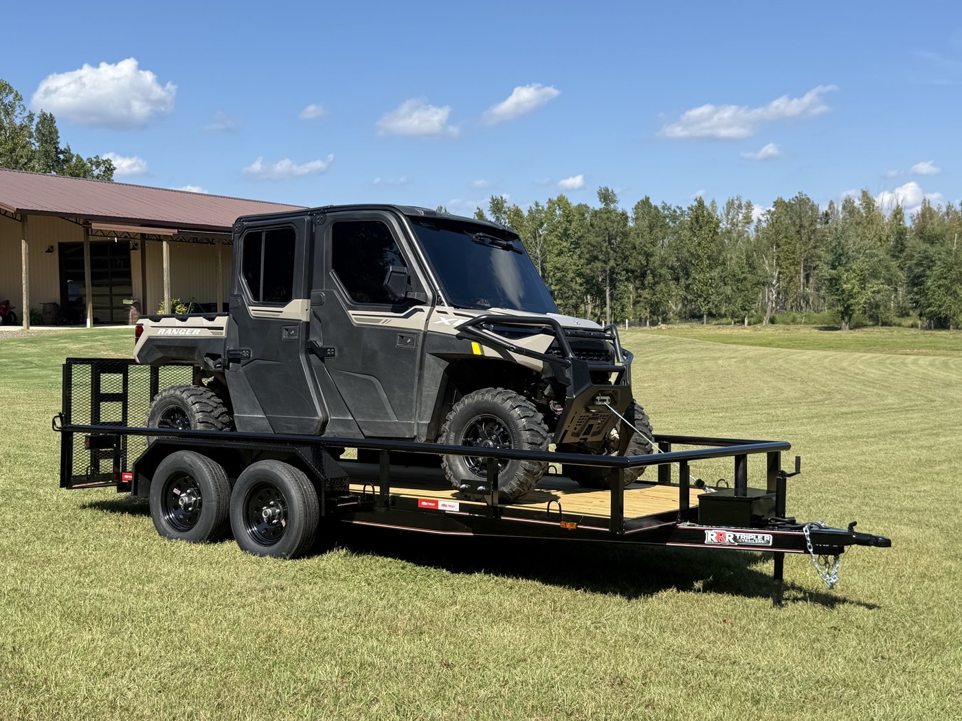 Polaris Ranger crew UTV strapped to a black Triple R tandem axle utility trailer