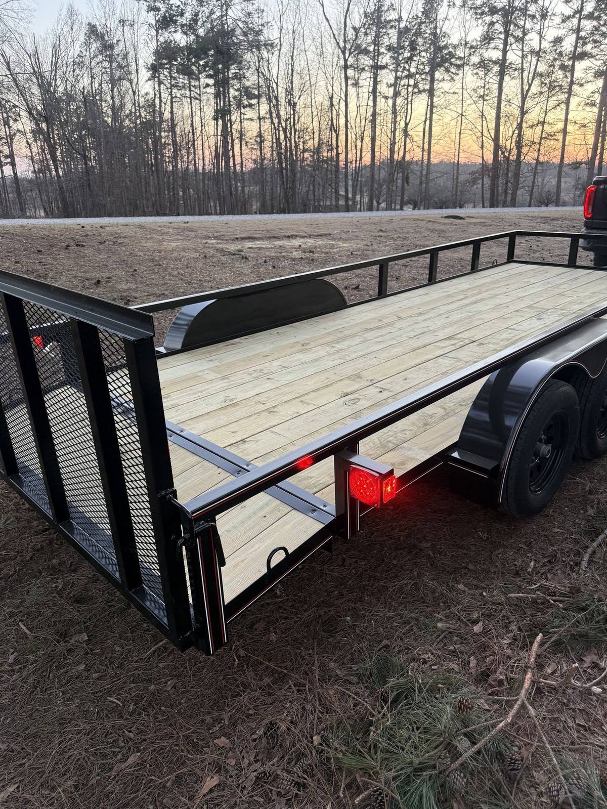 Wood deck utility trailer at sunset on the lot