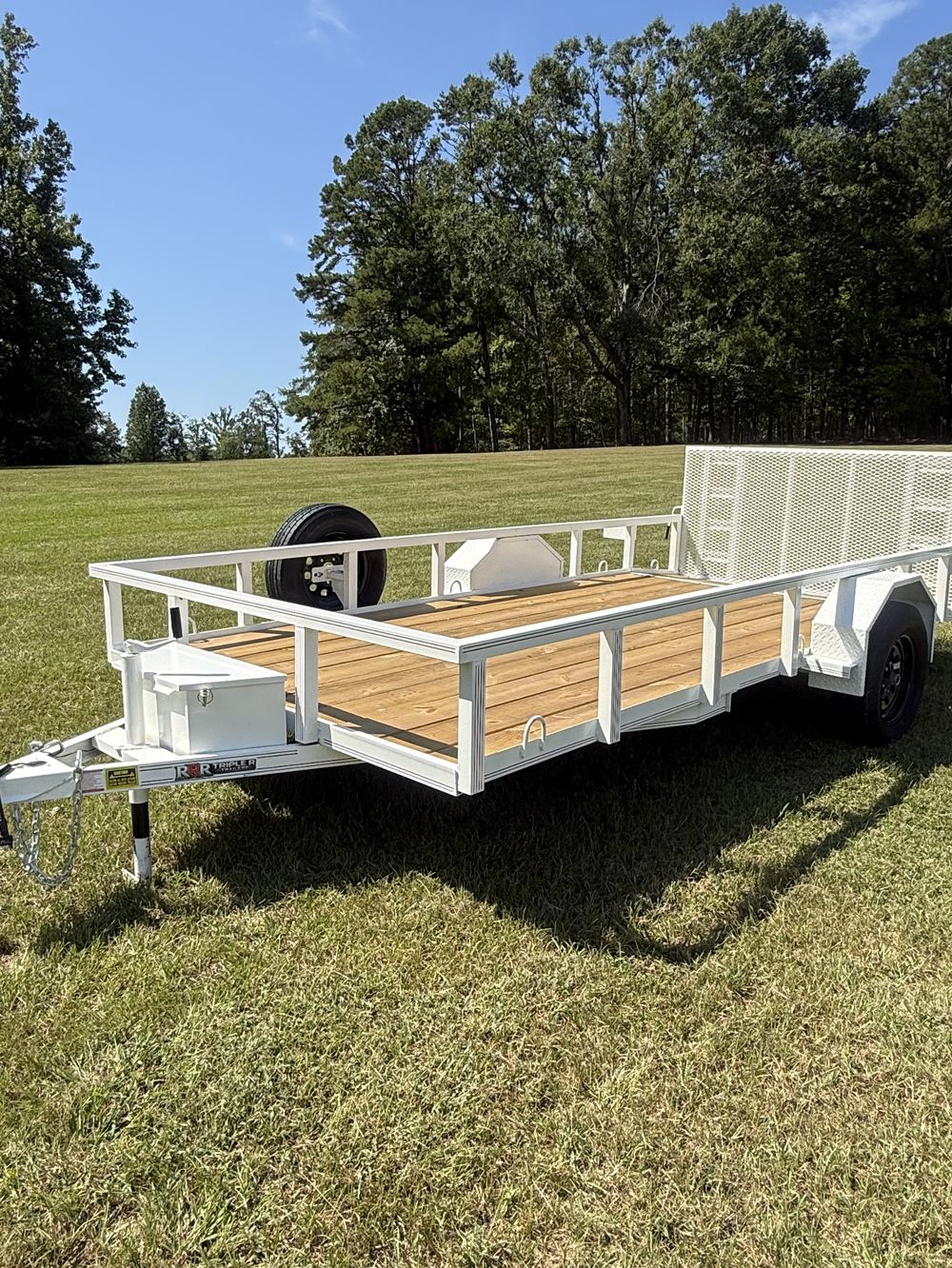 White Triple R utility trailer with treated wood deck and mesh side rails