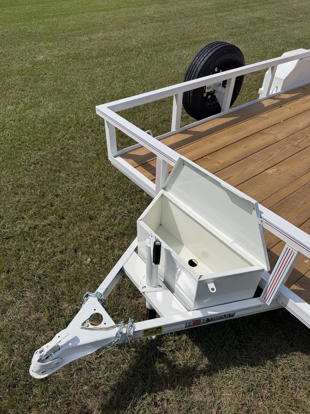 Open lockable tongue toolbox on the A-frame of a white Triple R utility trailer